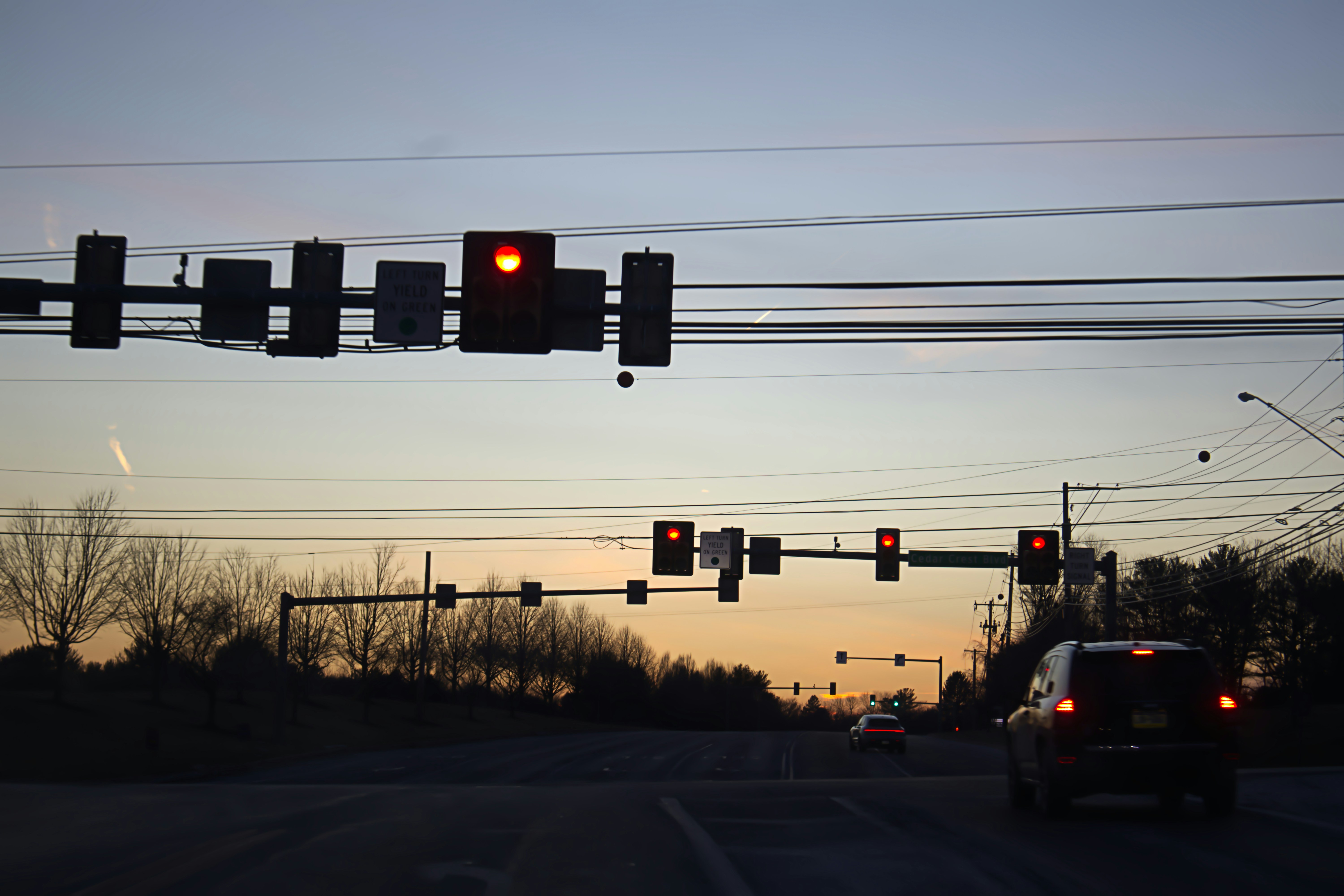 A traffic light hanging over a street filled with traffic