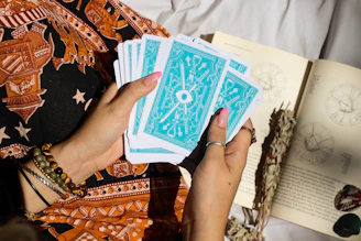 A woman holding a book and playing cards