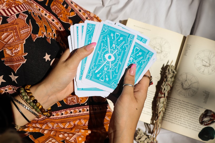 A woman holding a book and playing cards