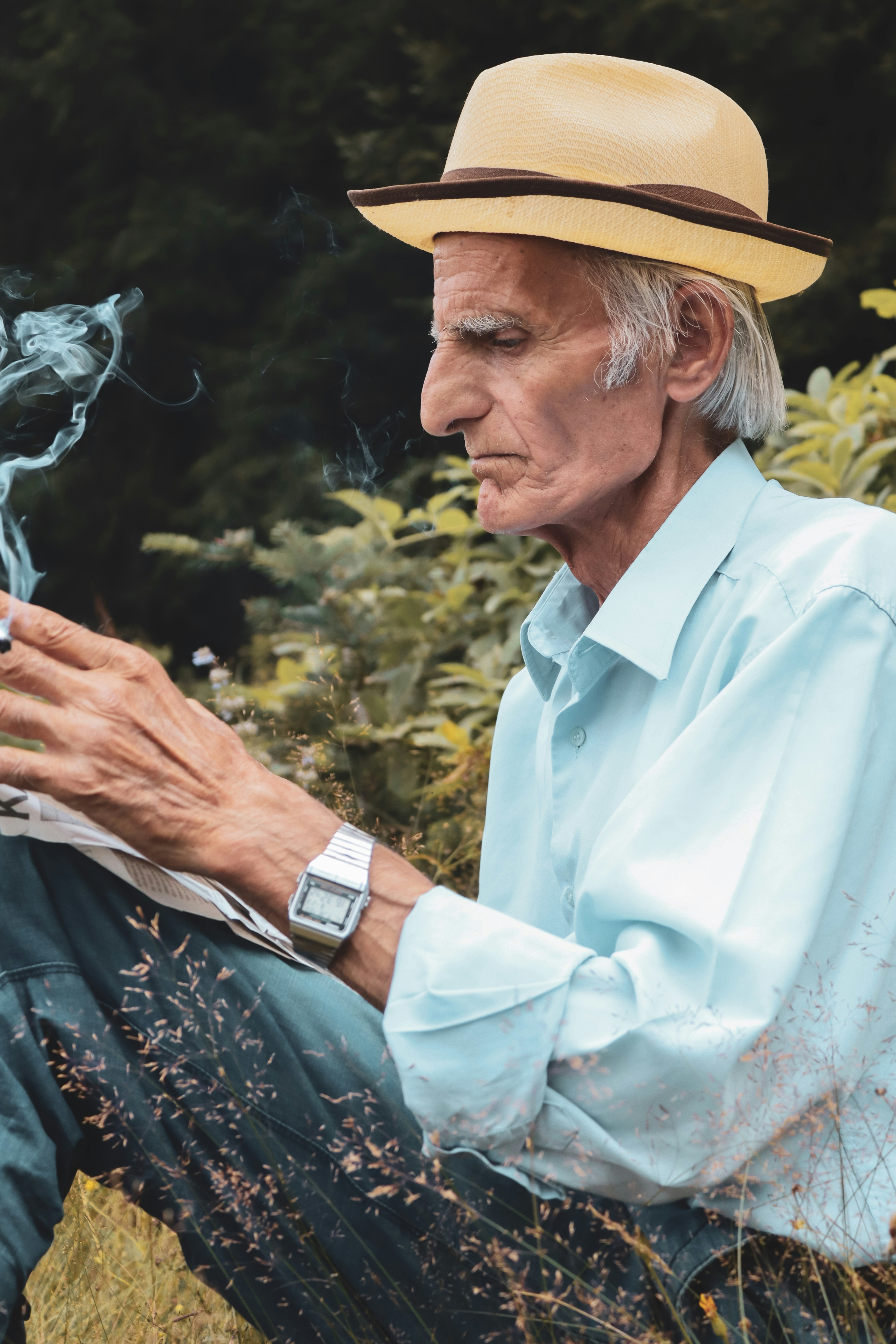um, homem, sentando, em, um, campo, com, um, cigarro, em, seu, mão