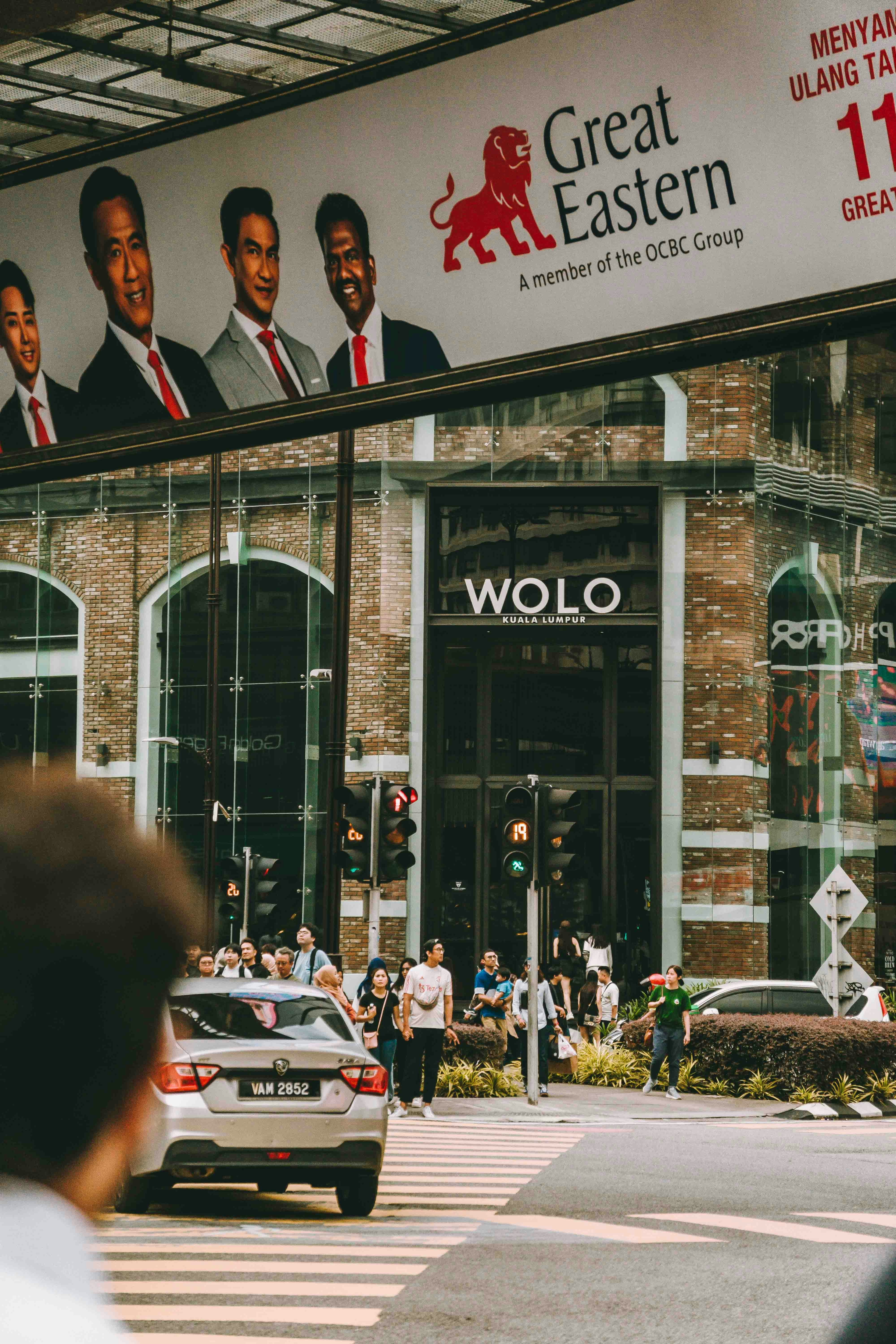 A group of people crossing a street in front of a building