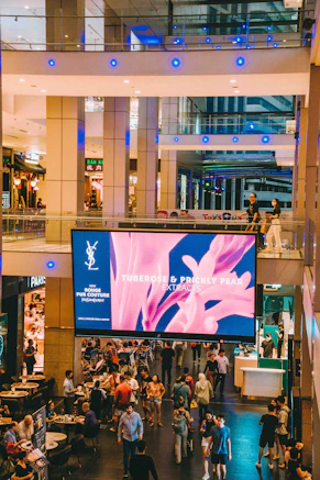 A group of people walking around a shopping mall