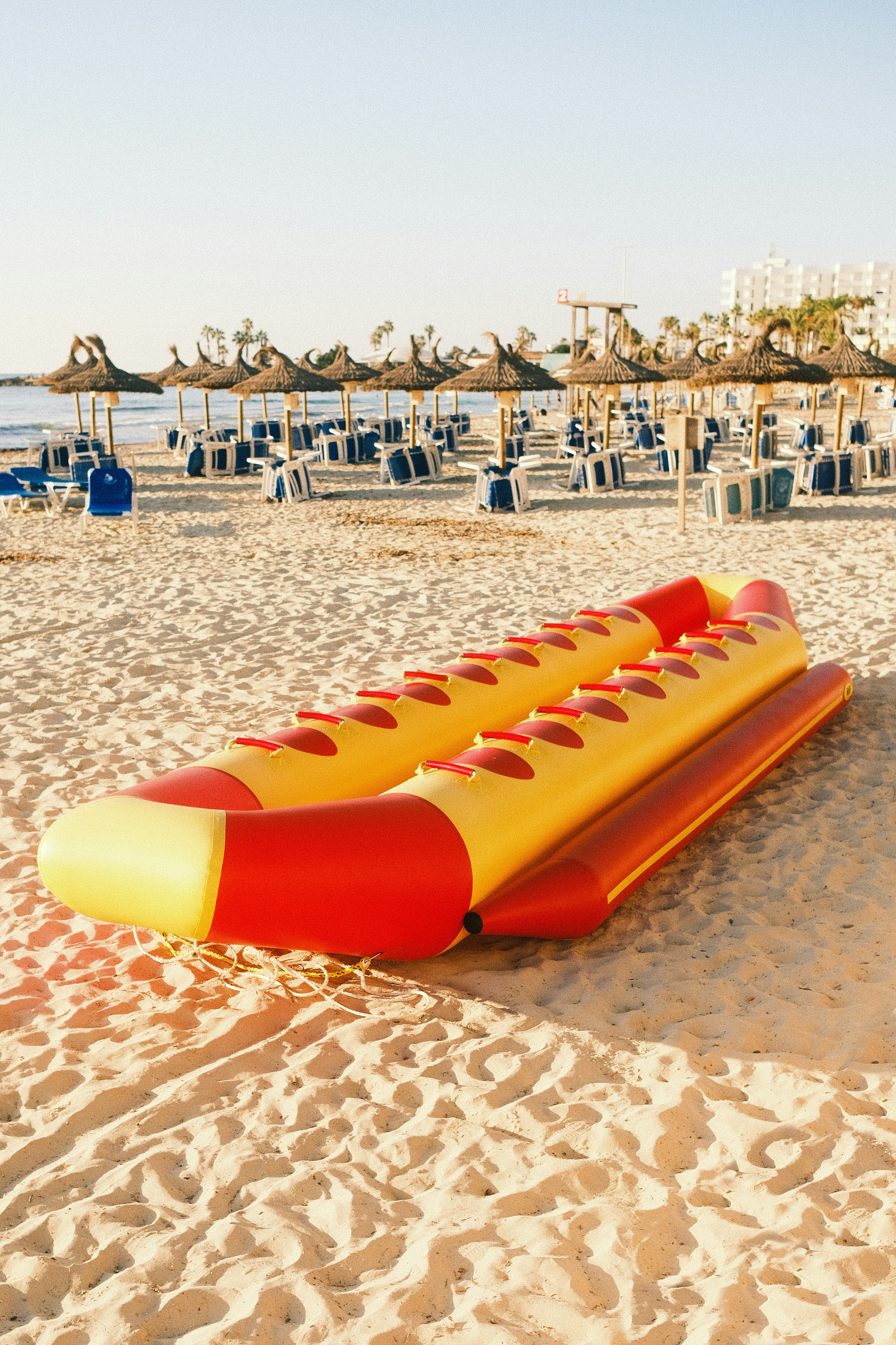 A yellow and red raft sitting on top of a sandy beach photo – Free ...