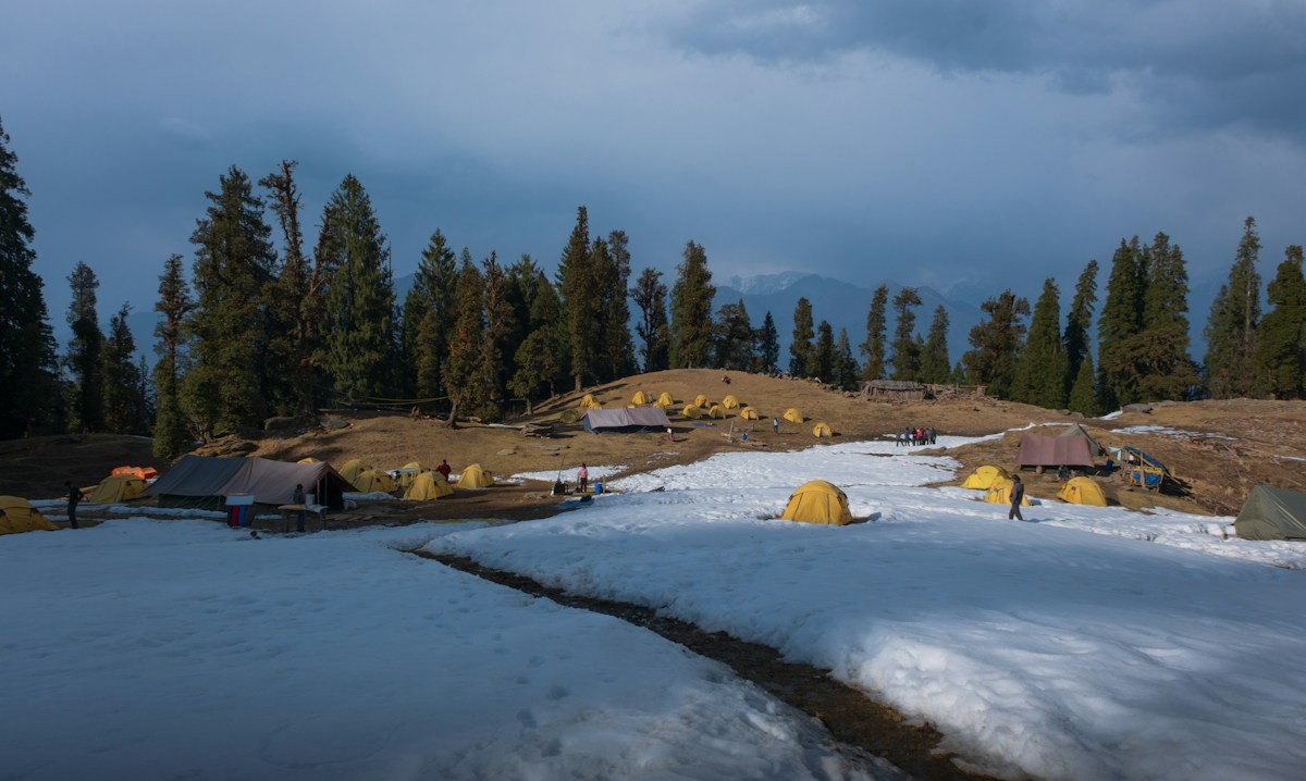 Snow-covered field with distant tents, illustrating a winter scout camping checklist setting.