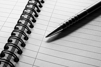 A notebook with a pen on top of it