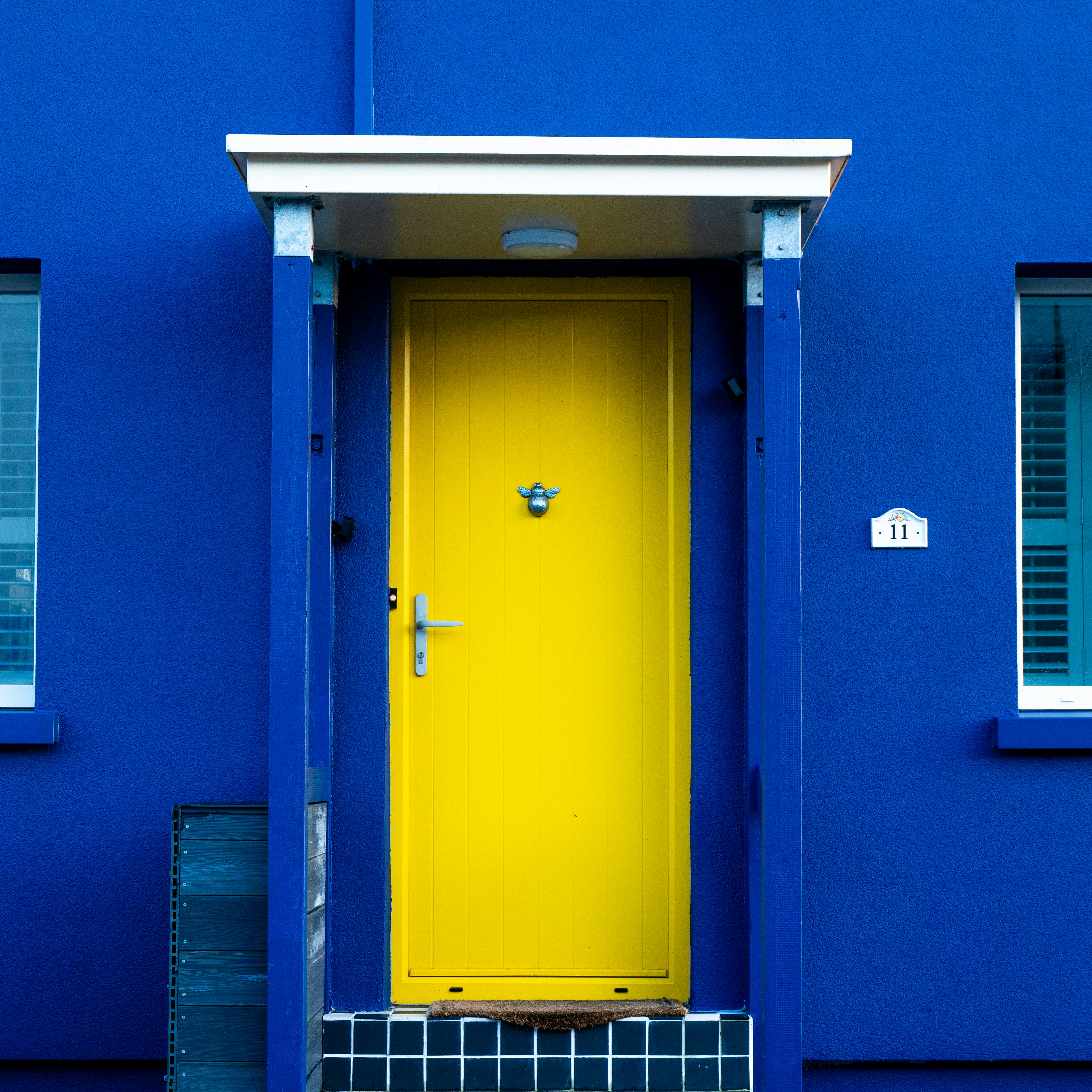 A blue building with a yellow door and window