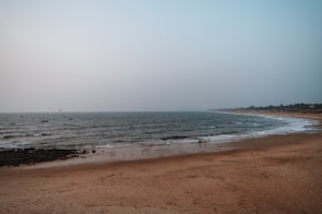 A sandy beach with waves coming in to shore