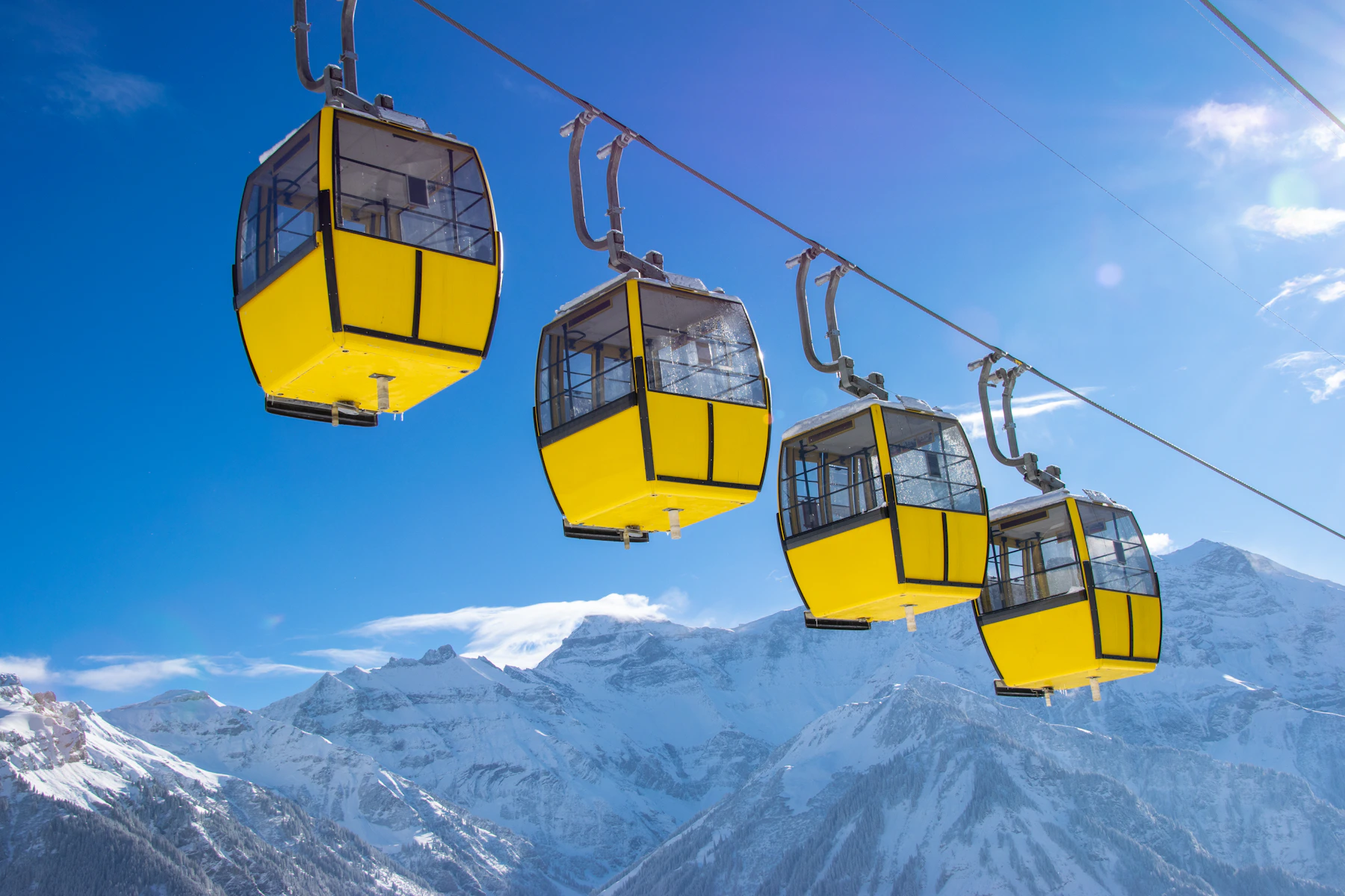 Gelbe Gondelbahn vor verschneiten Bergen bei Braunwald