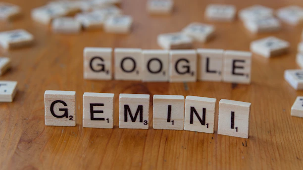 A wooden table topped with scrabble tiles spelling google, genni, and