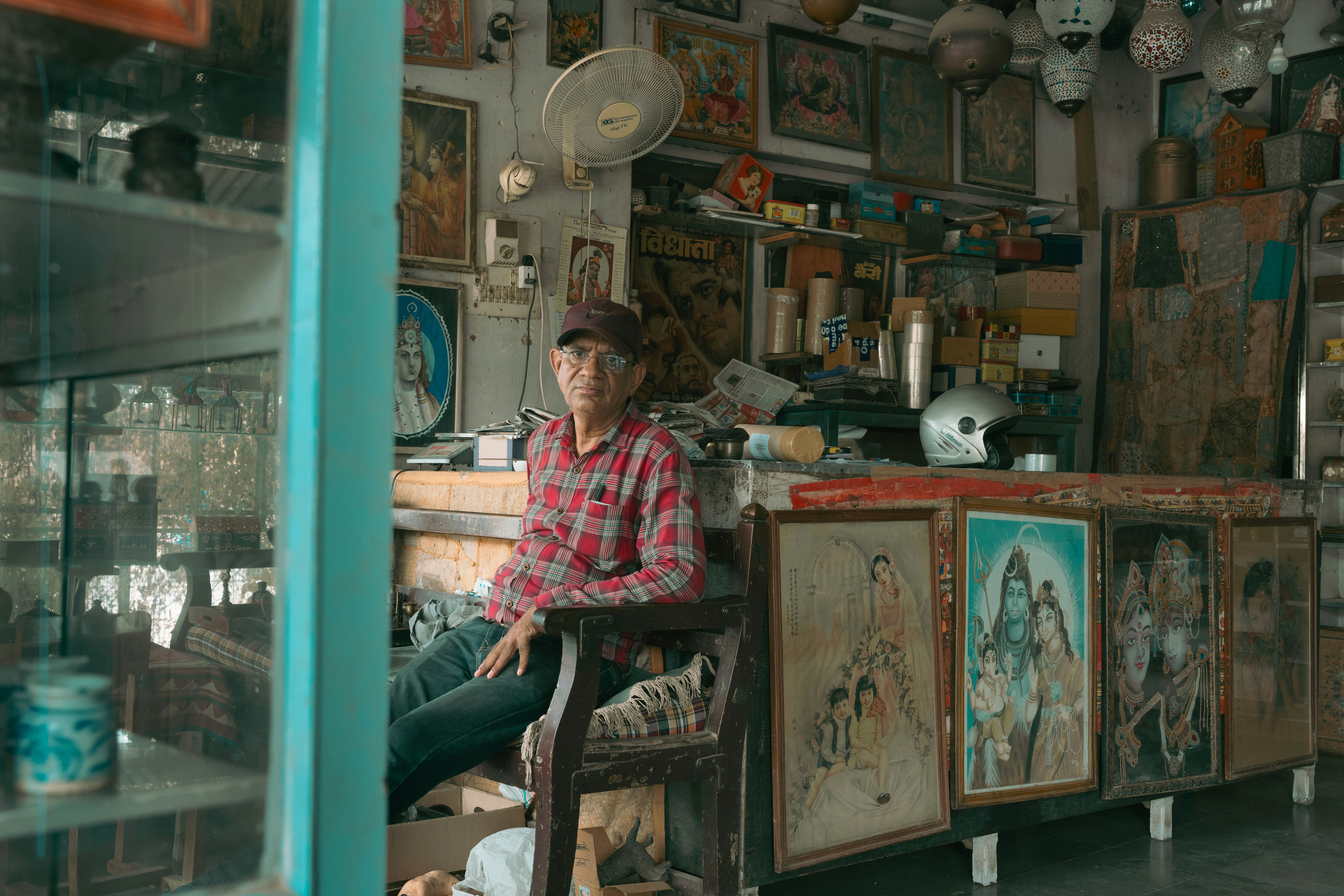 A man sitting on a chair in a room filled with antiques