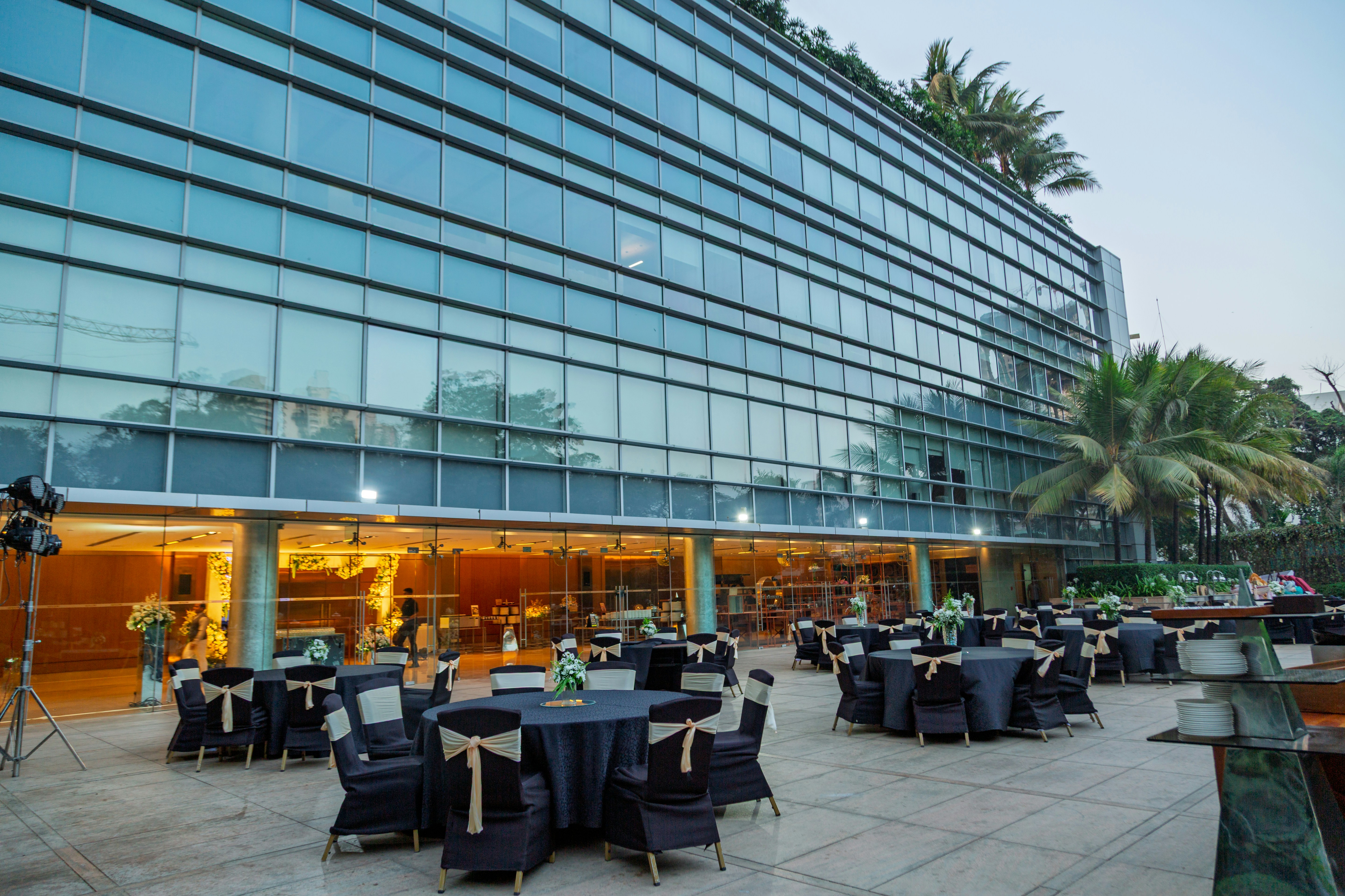 A large building with tables and chairs in front of it
