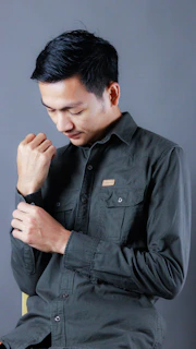 A man in a black shirt is holding his hands together