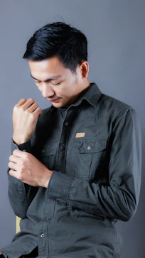 A man in a black shirt is holding his hands together