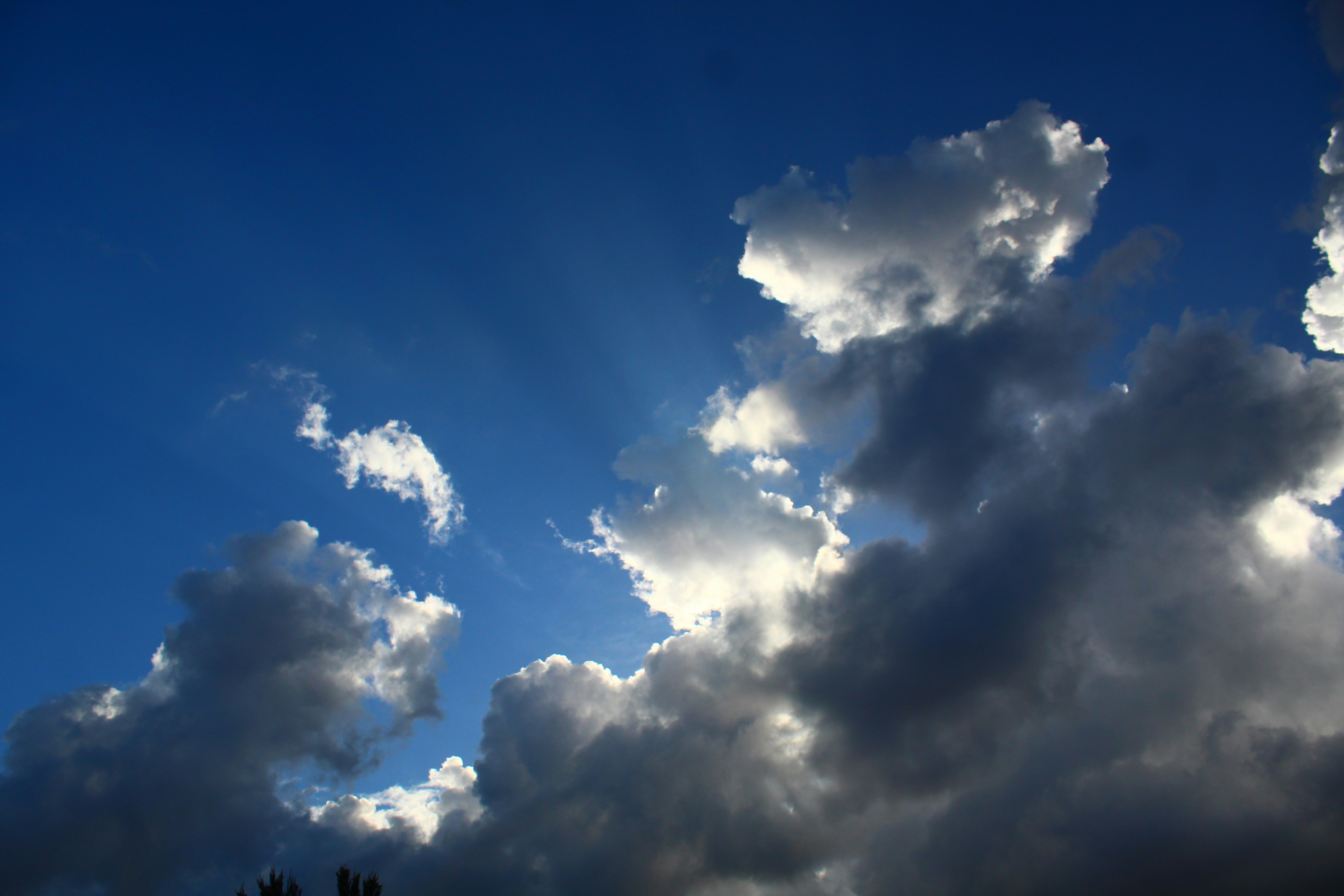 The sun is shining through the clouds in the sky