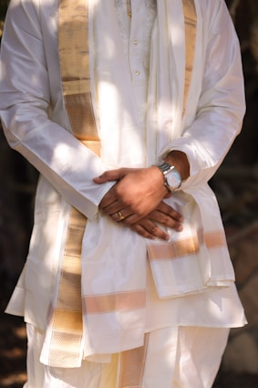 A man wearing a white and gold outfit