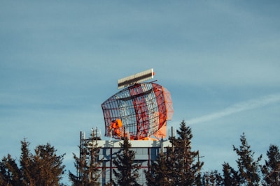 A tall tower with a red and white structure on top of it