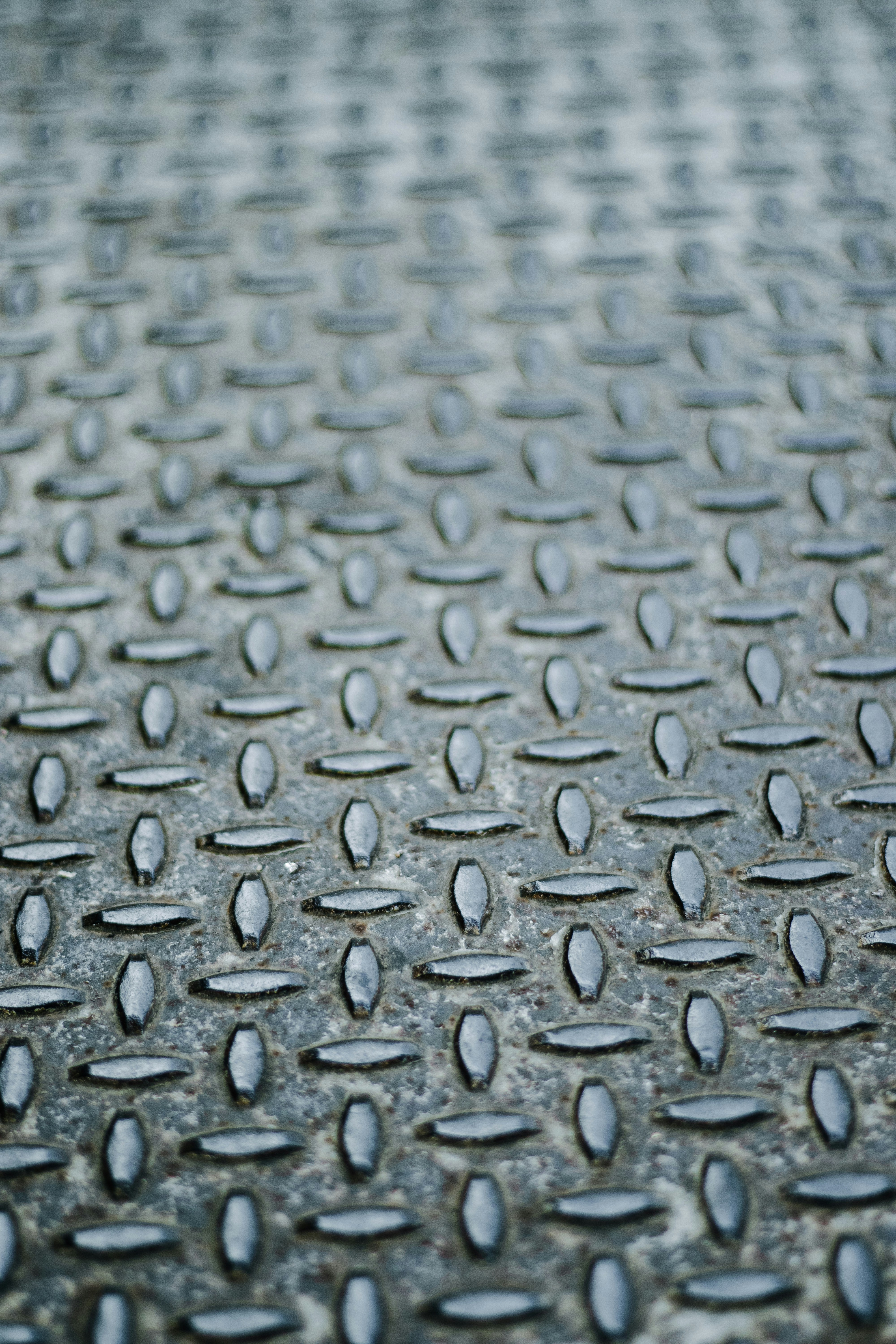 A close up of a metal surface with drops of water on it