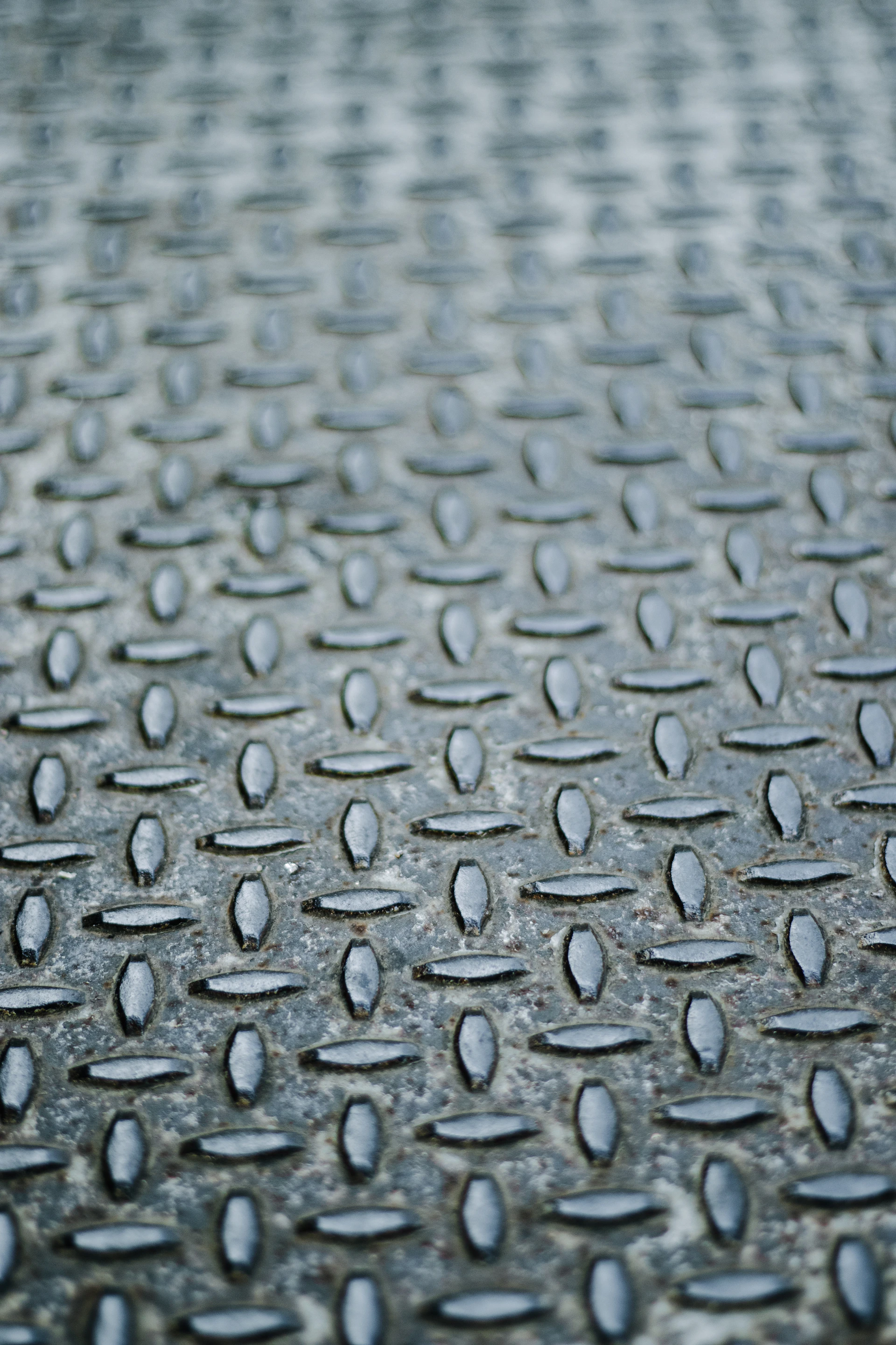 A close up of a metal surface with drops of water on it