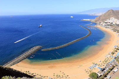An aerial view of a beach with a boat in the water