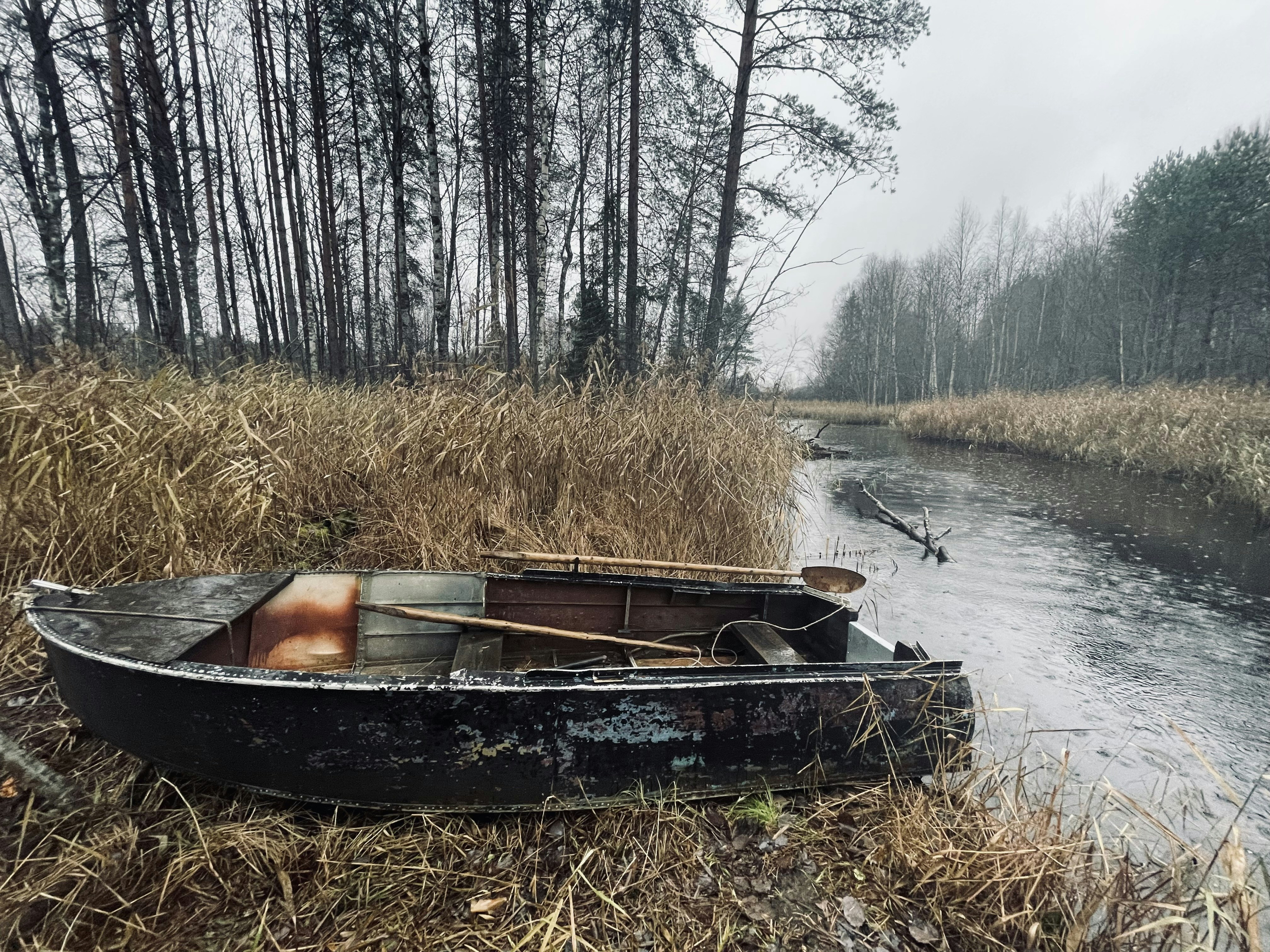 A small boat sitting on top of a dry grass field