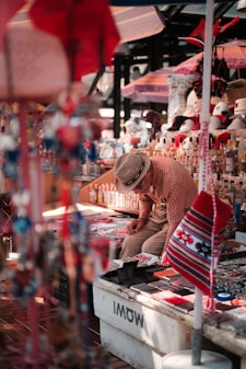 A man is looking at items in a market