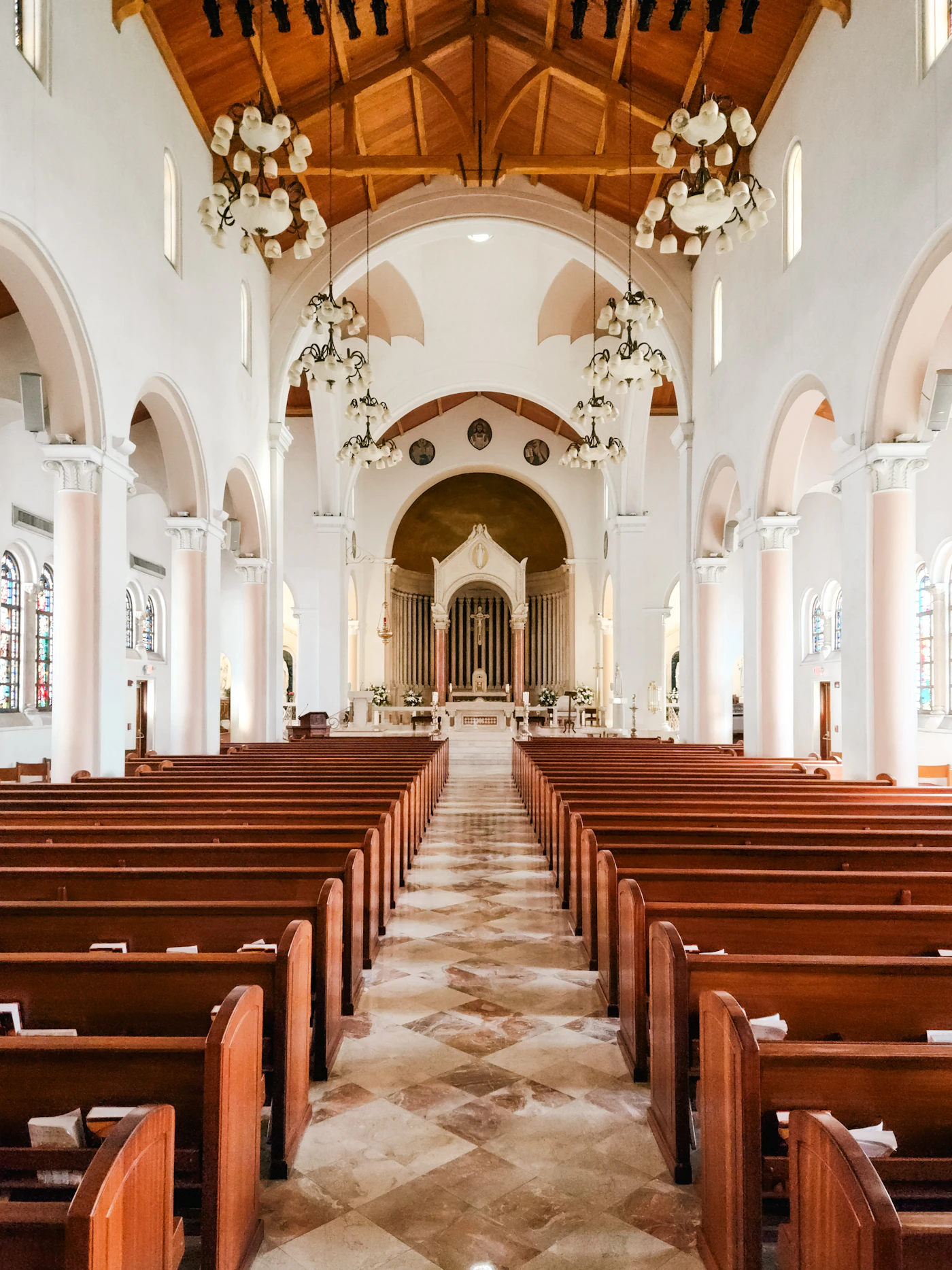 Empty church interior with wooden pews and stained glass windows showing the formal religious space that requires photographers to work within denomination-specific restrictions