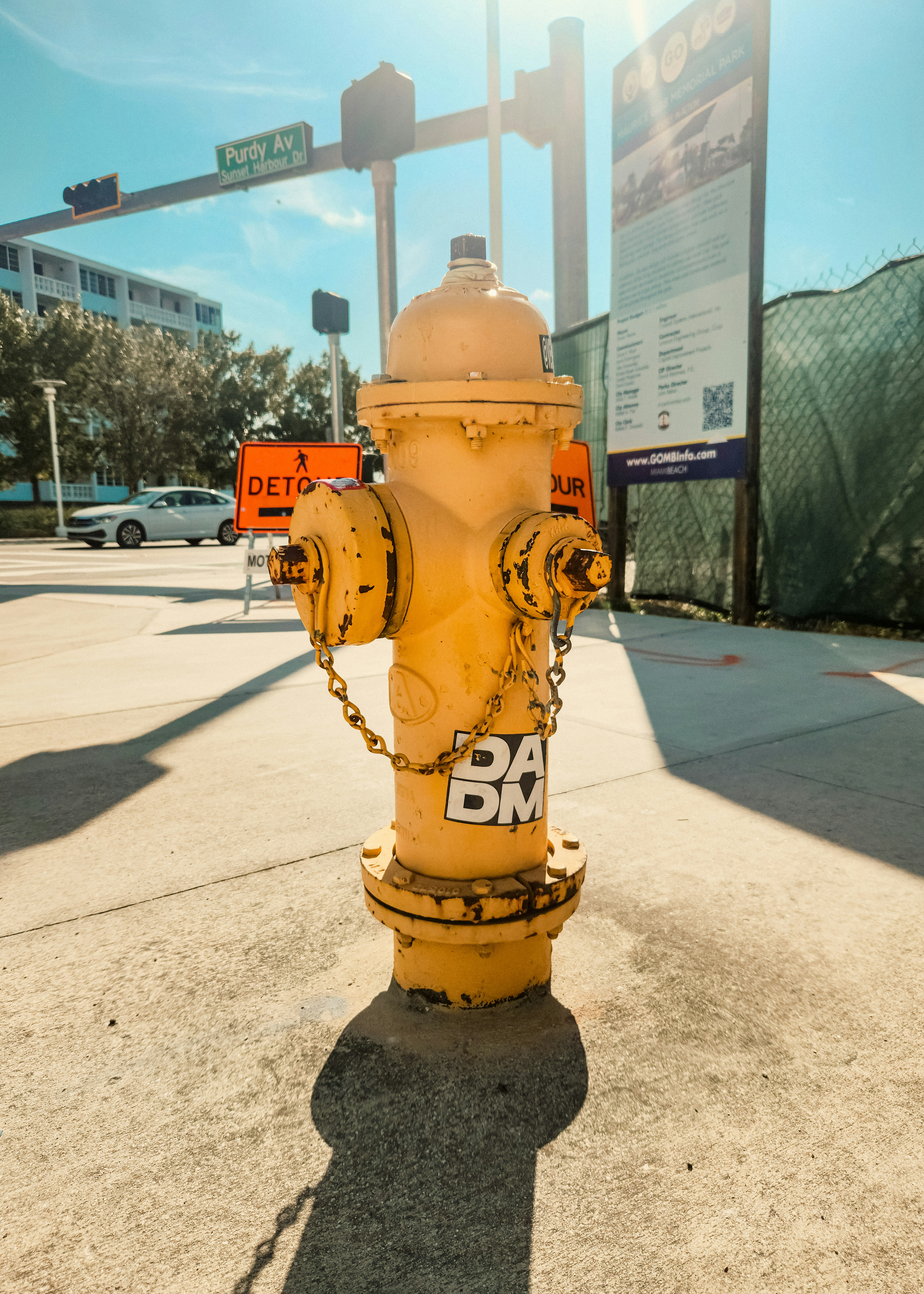A yellow fire hydrant sitting on the side of a road