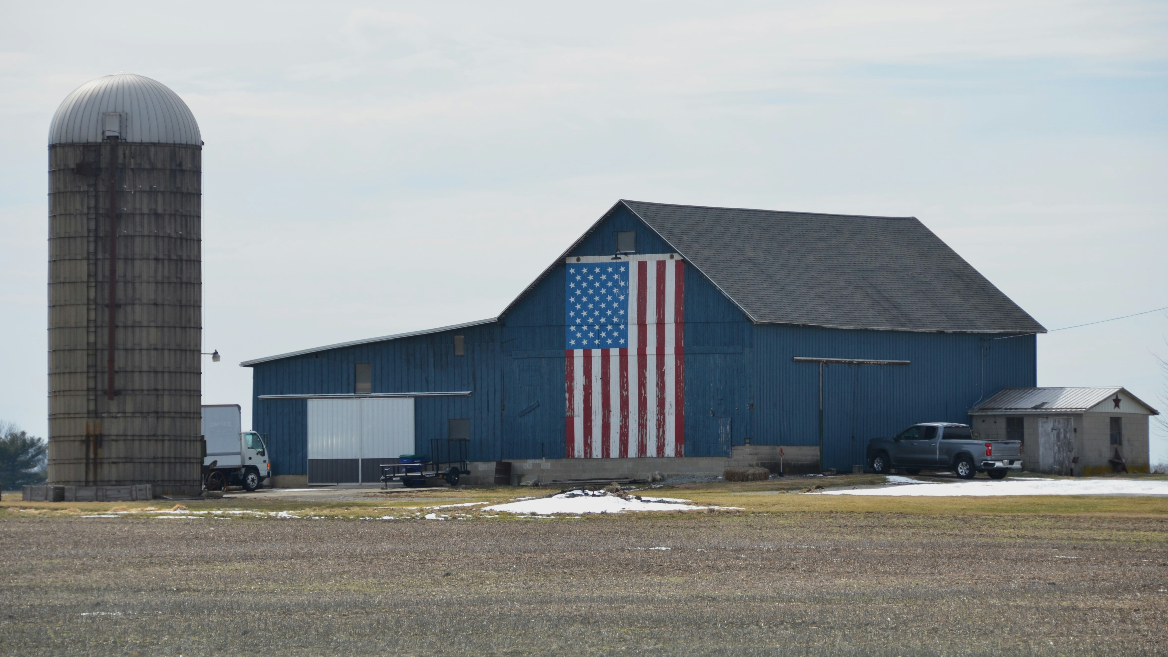 A barn with an american flag painted on the side of it