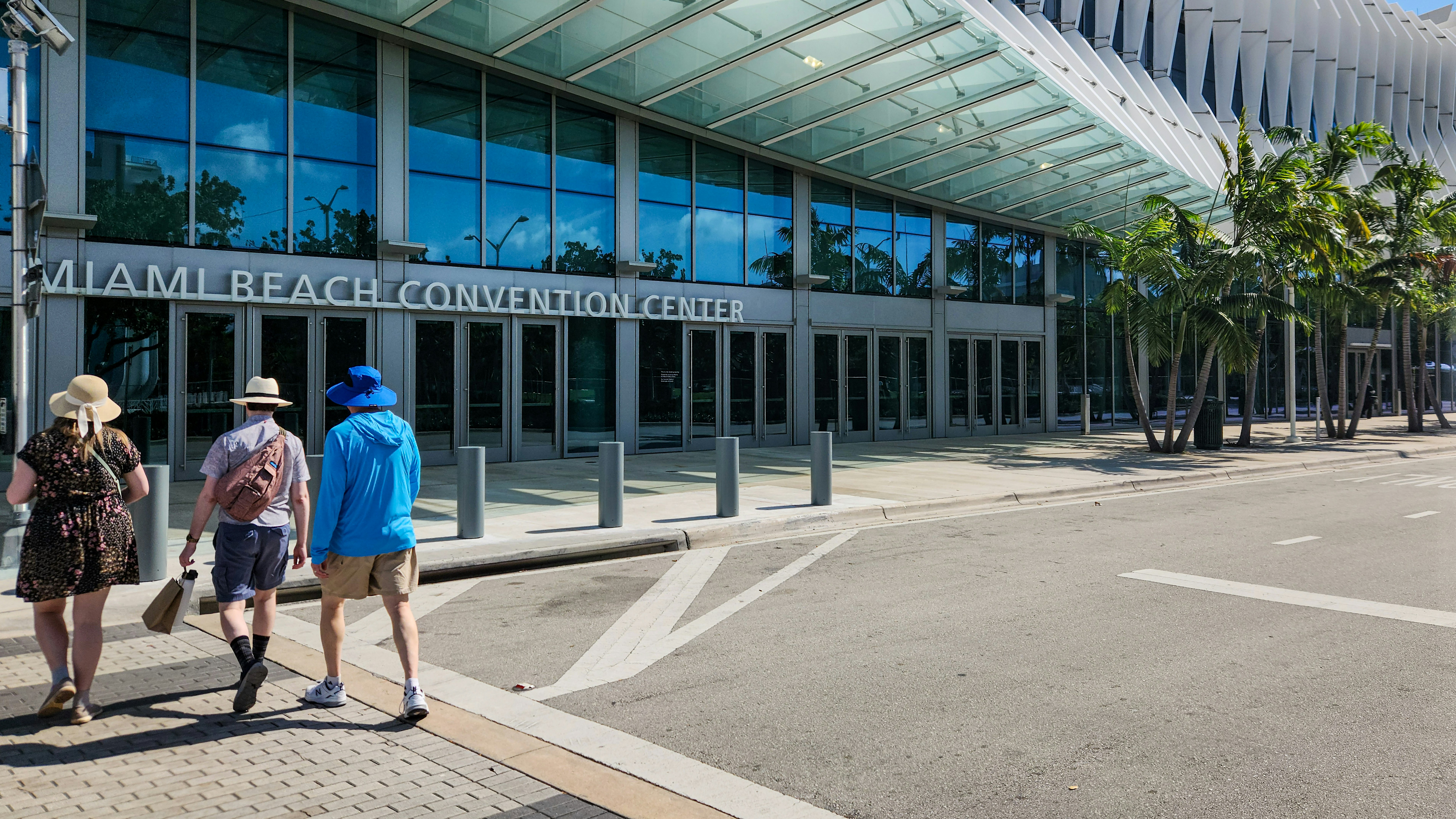 Three people walking in front of a building