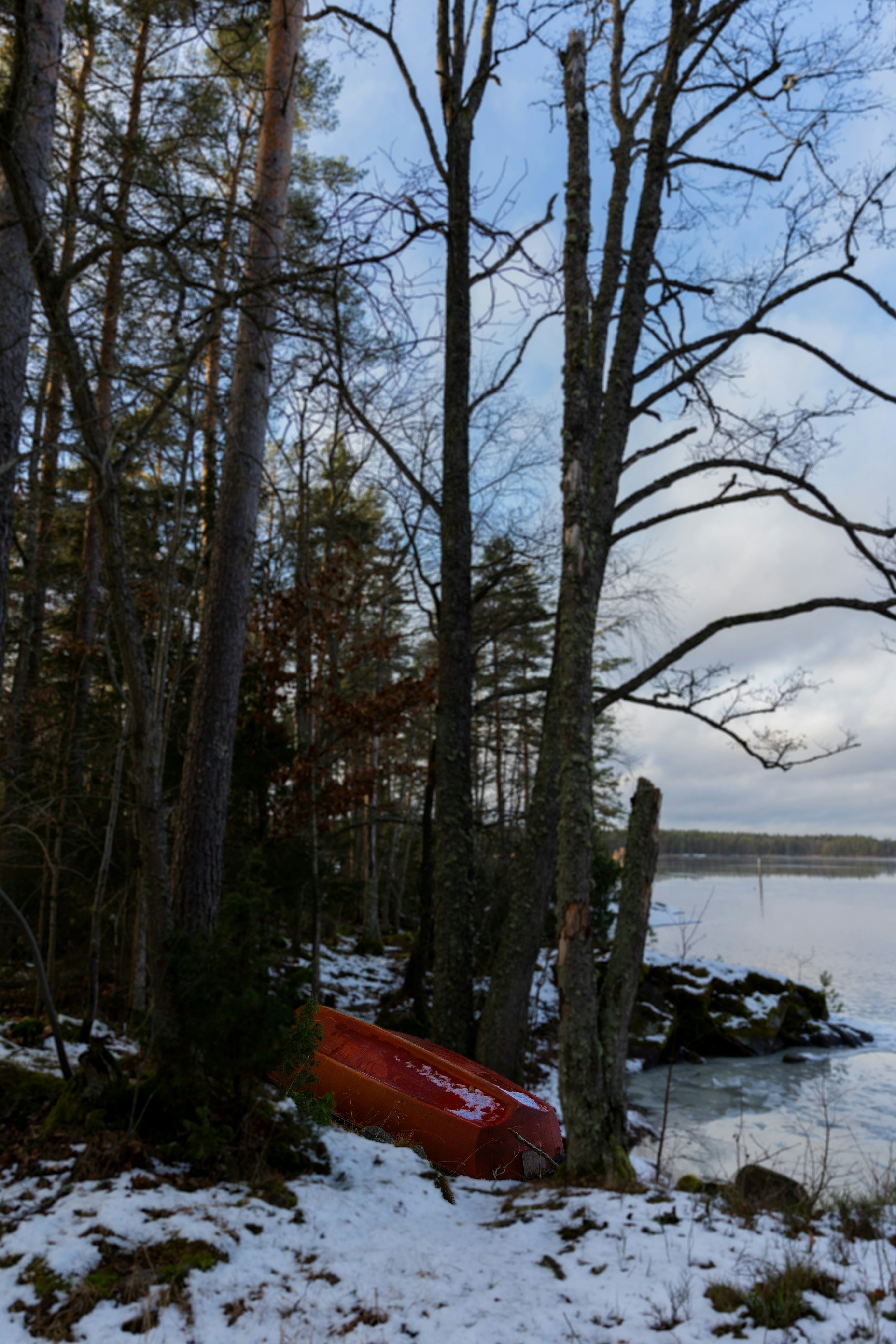 Una canoa roja sentada en la orilla de un lago