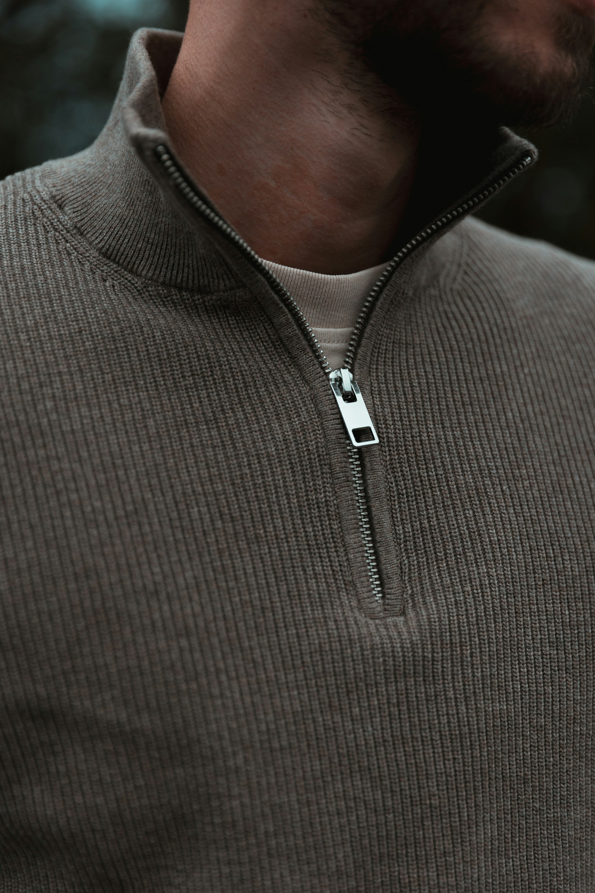 A man wearing a gray sweater with a zipper