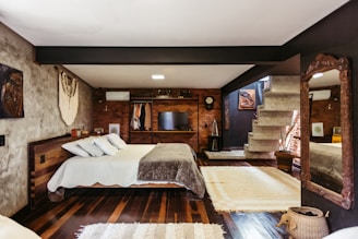 A bedroom with a large bed and a fireplace