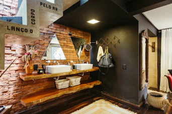 A bathroom with two sinks and a brick wall
