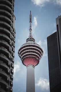 A tall tower with a sky scraper in the background