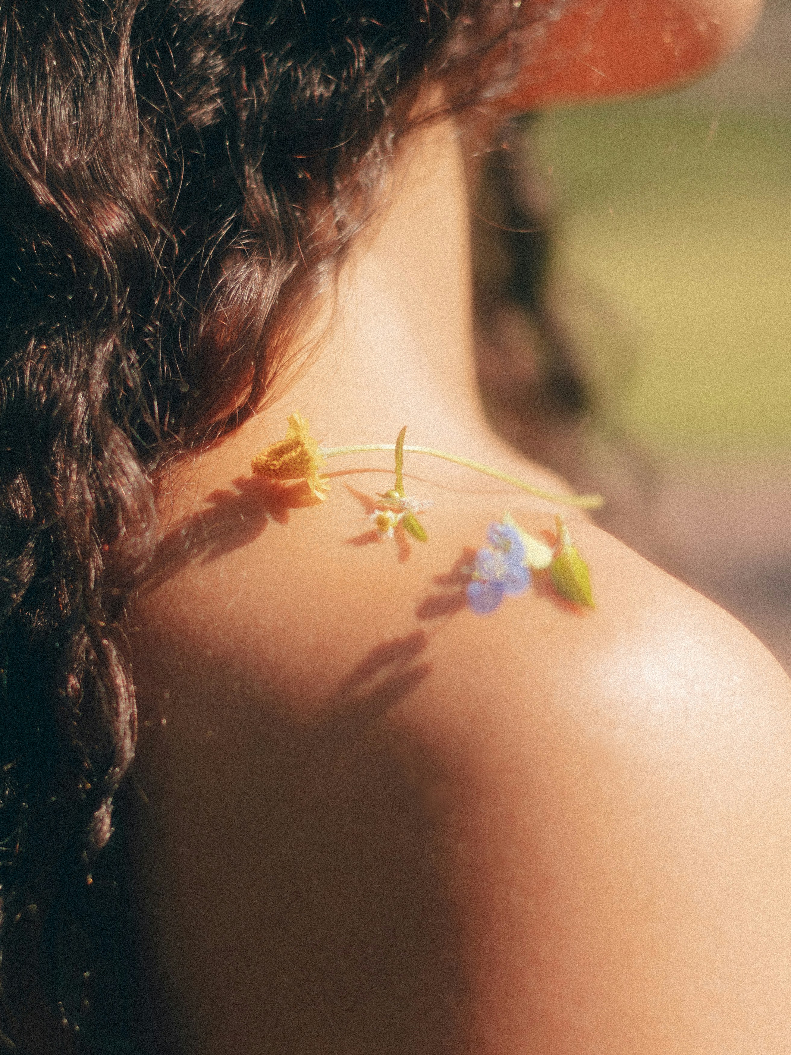 A close up of a woman's shoulder with flowers on it