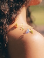 A close up of a woman's shoulder with flowers on it