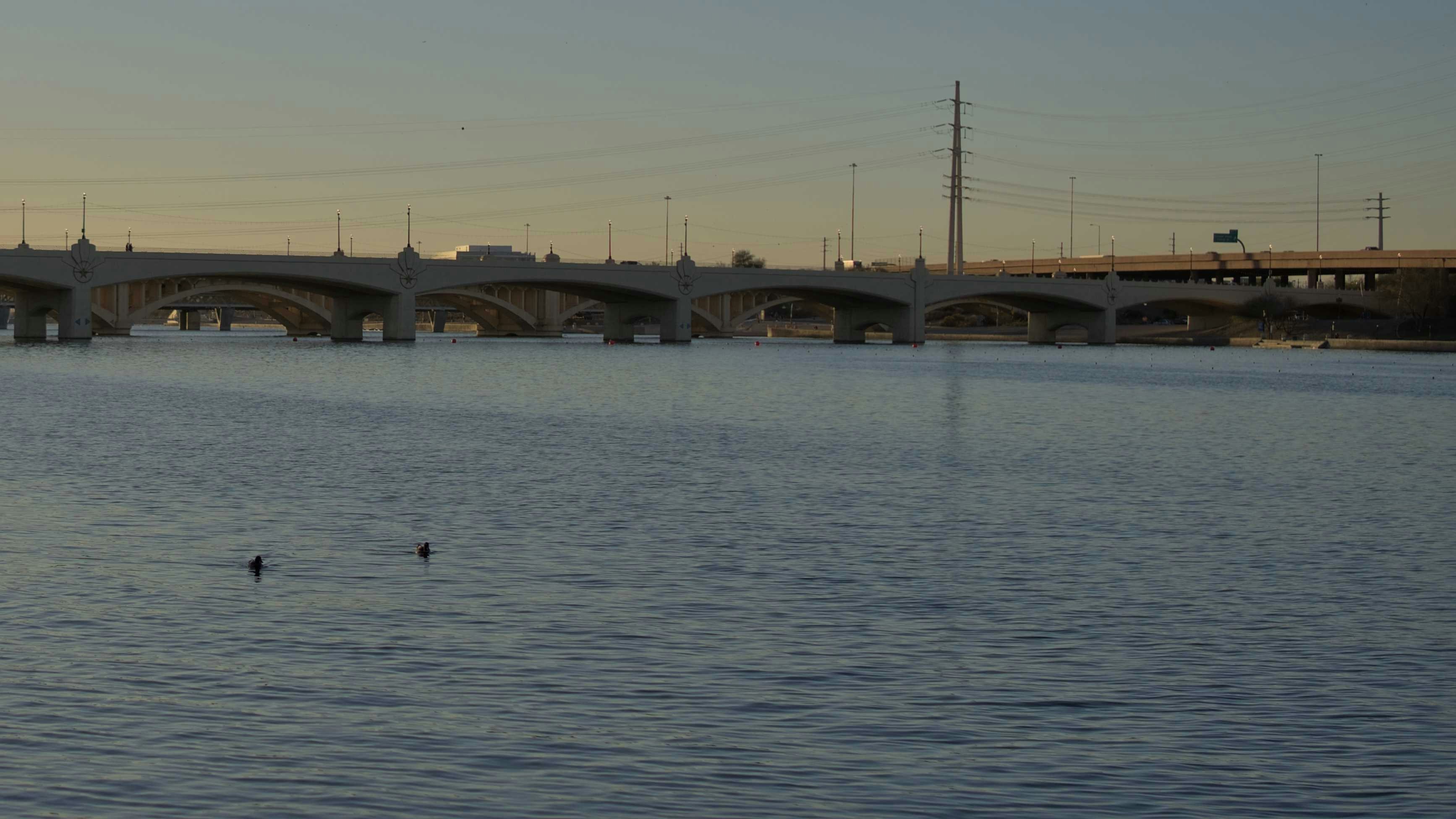 A large body of water with a bridge in the background