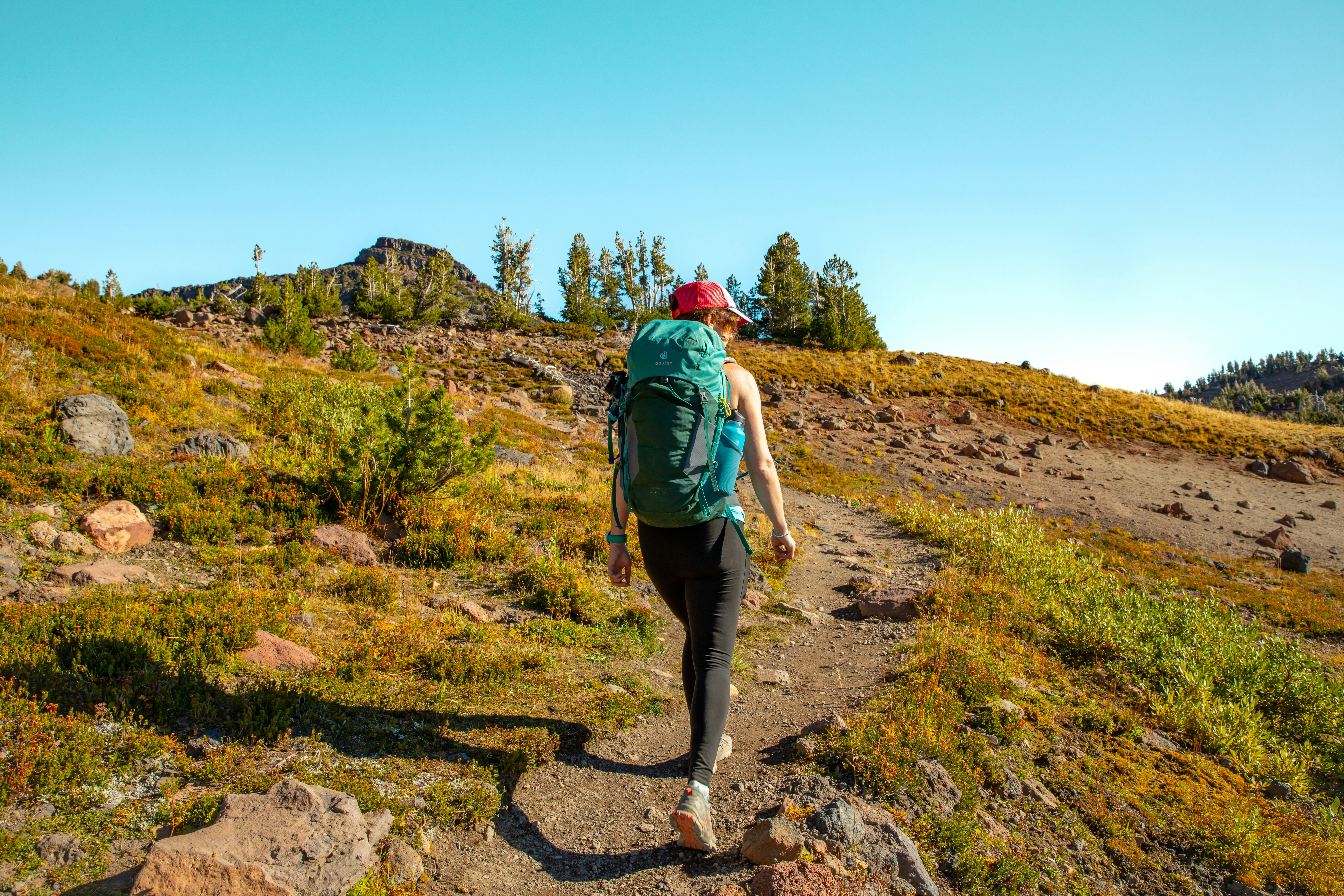 A man hiking up a trail in the mountains