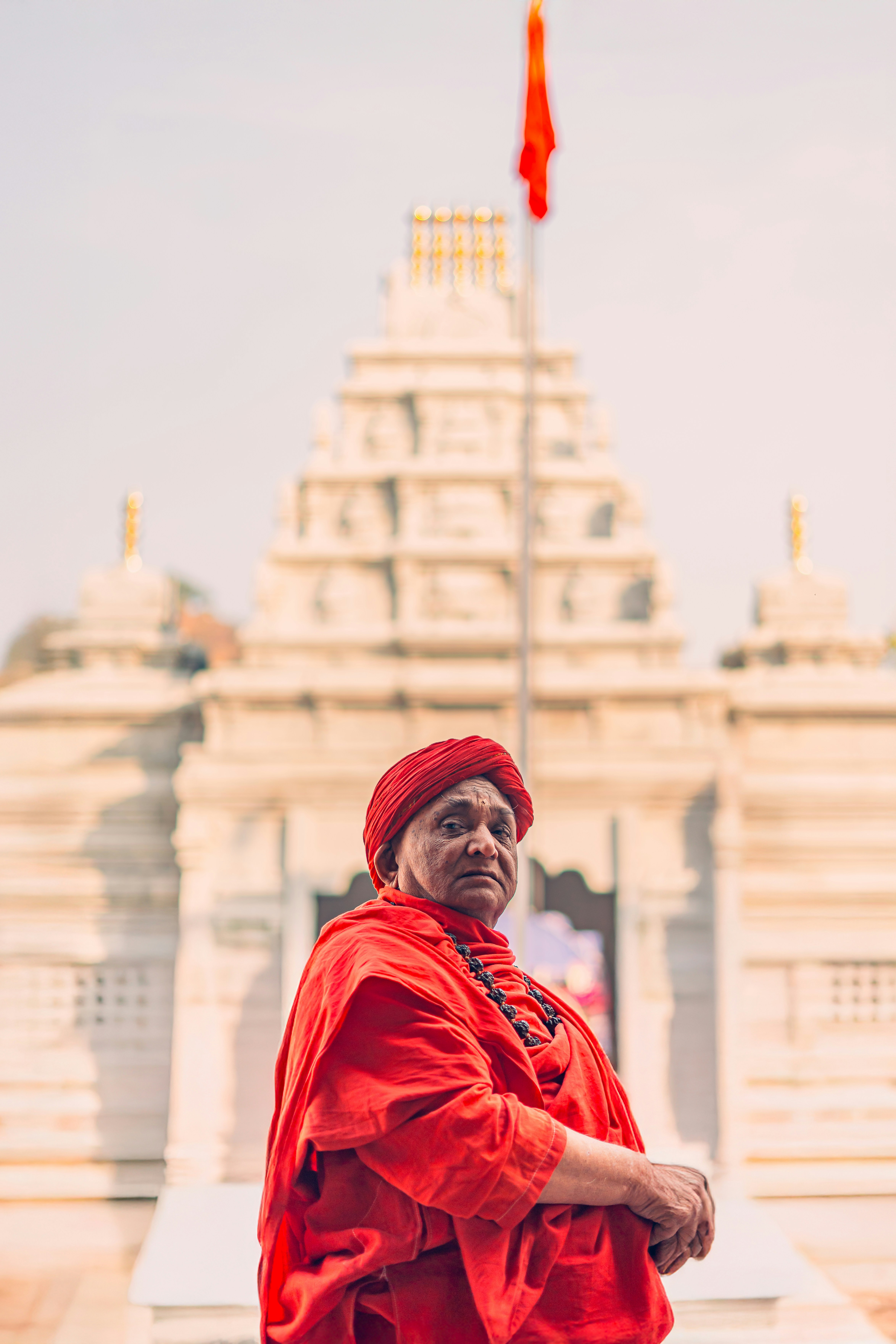A man in a red outfit standing in front of a building