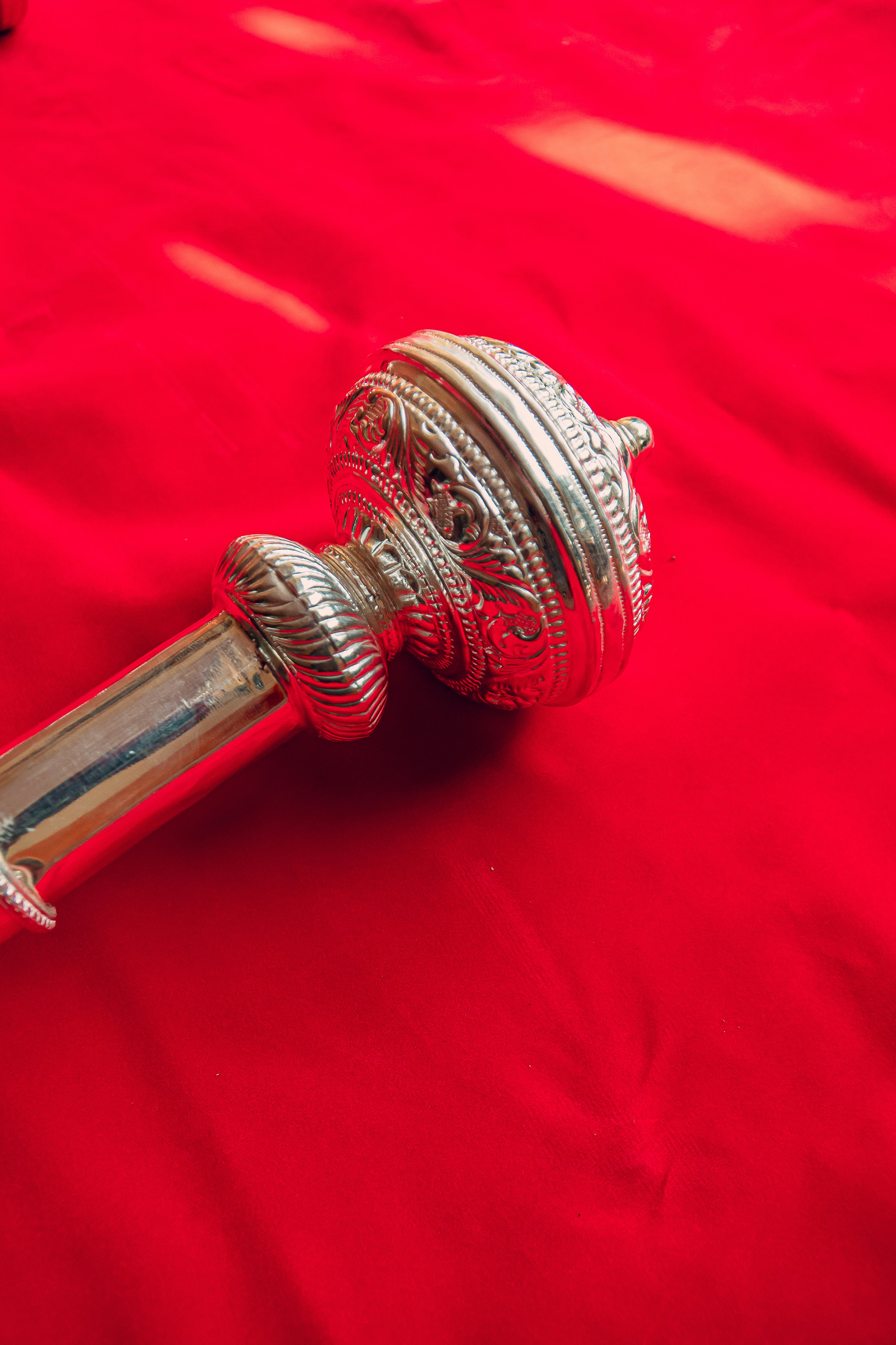 Un primer plano de un objeto metálico sobre una tela roja