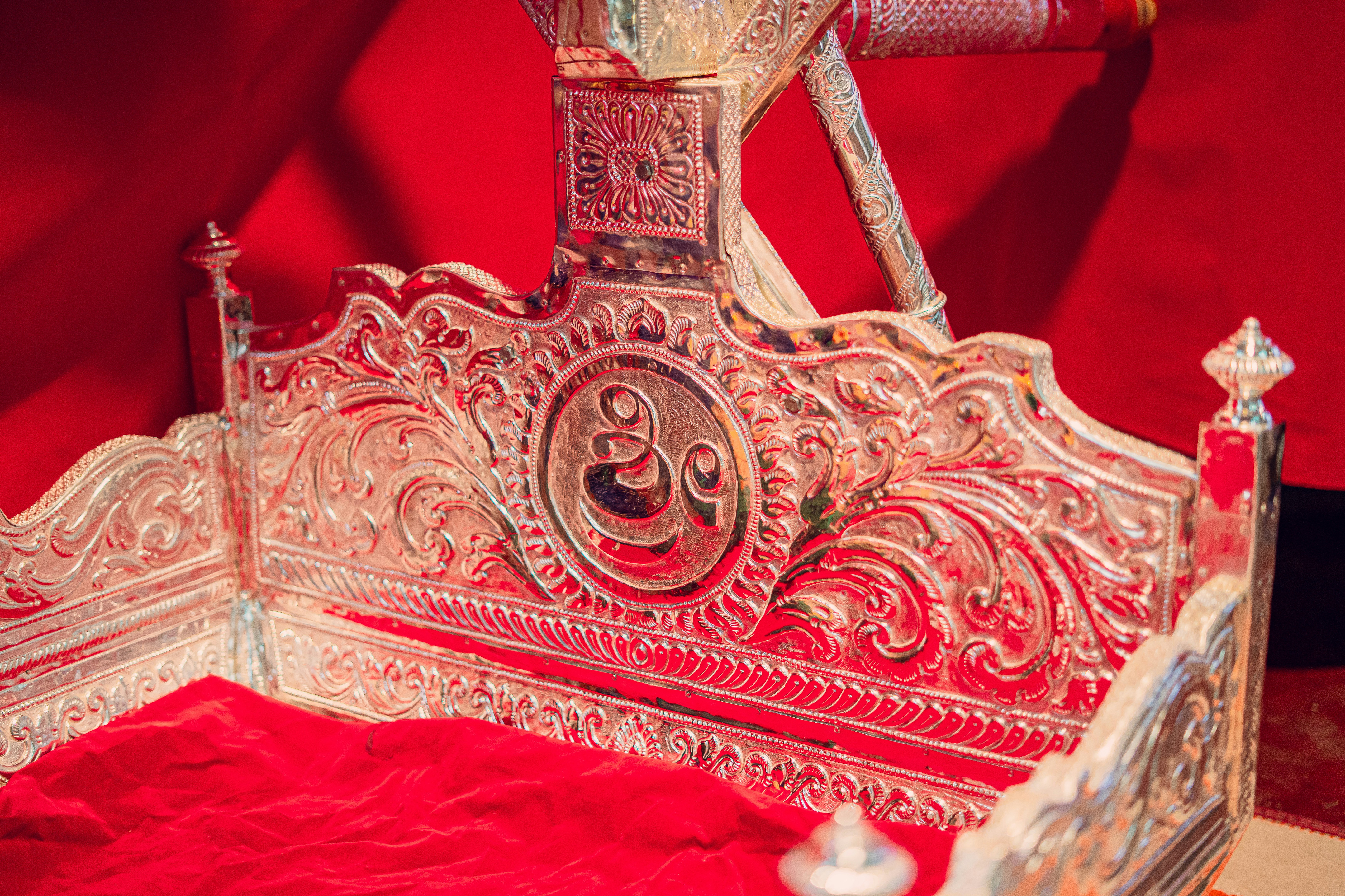 An ornately decorated bed with a red blanket