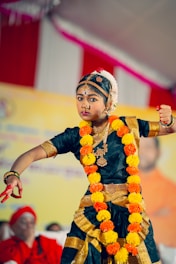 A young boy dressed in a traditional indian dance costume