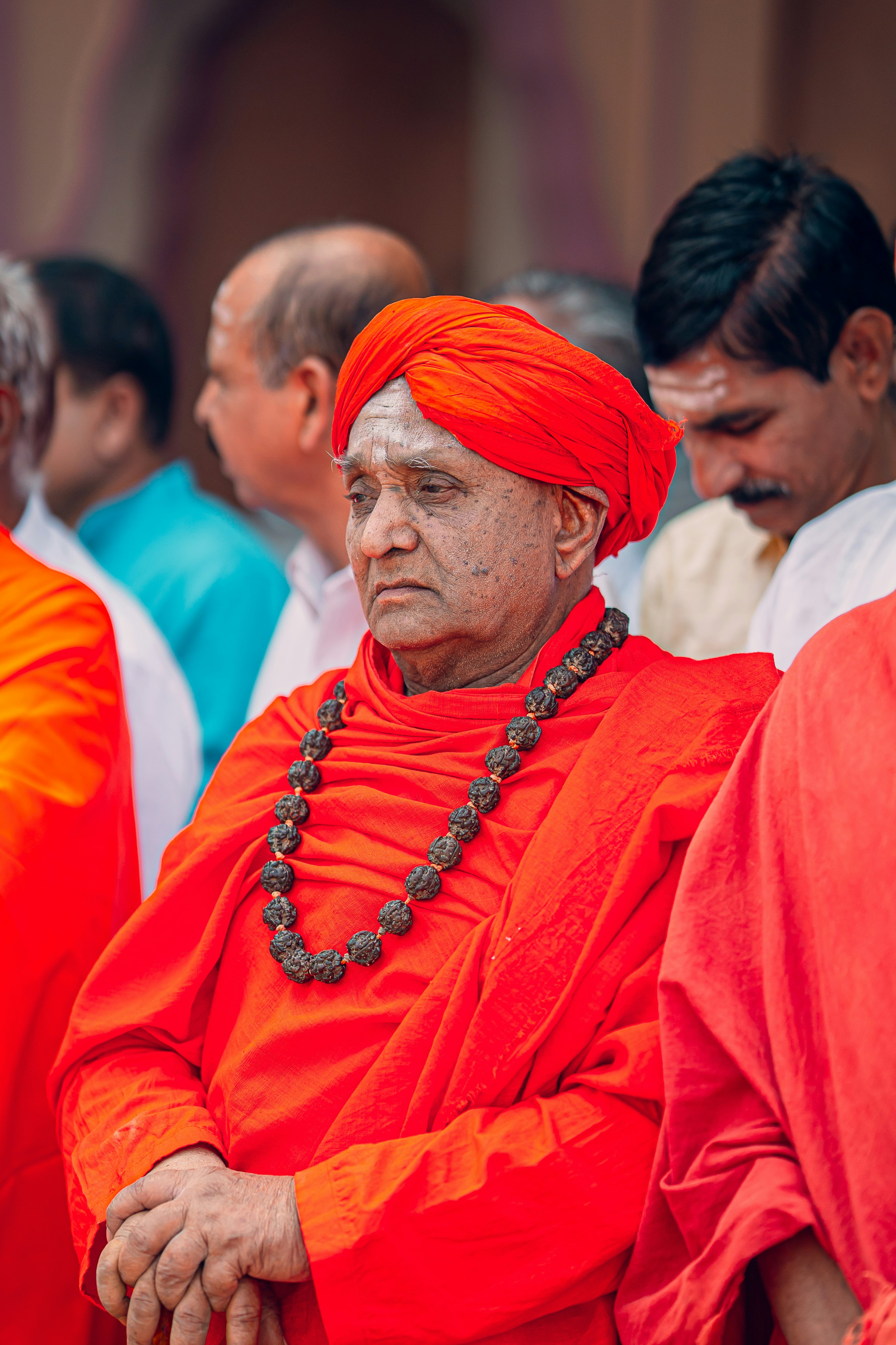 A man in a red turban sitting in front of other men