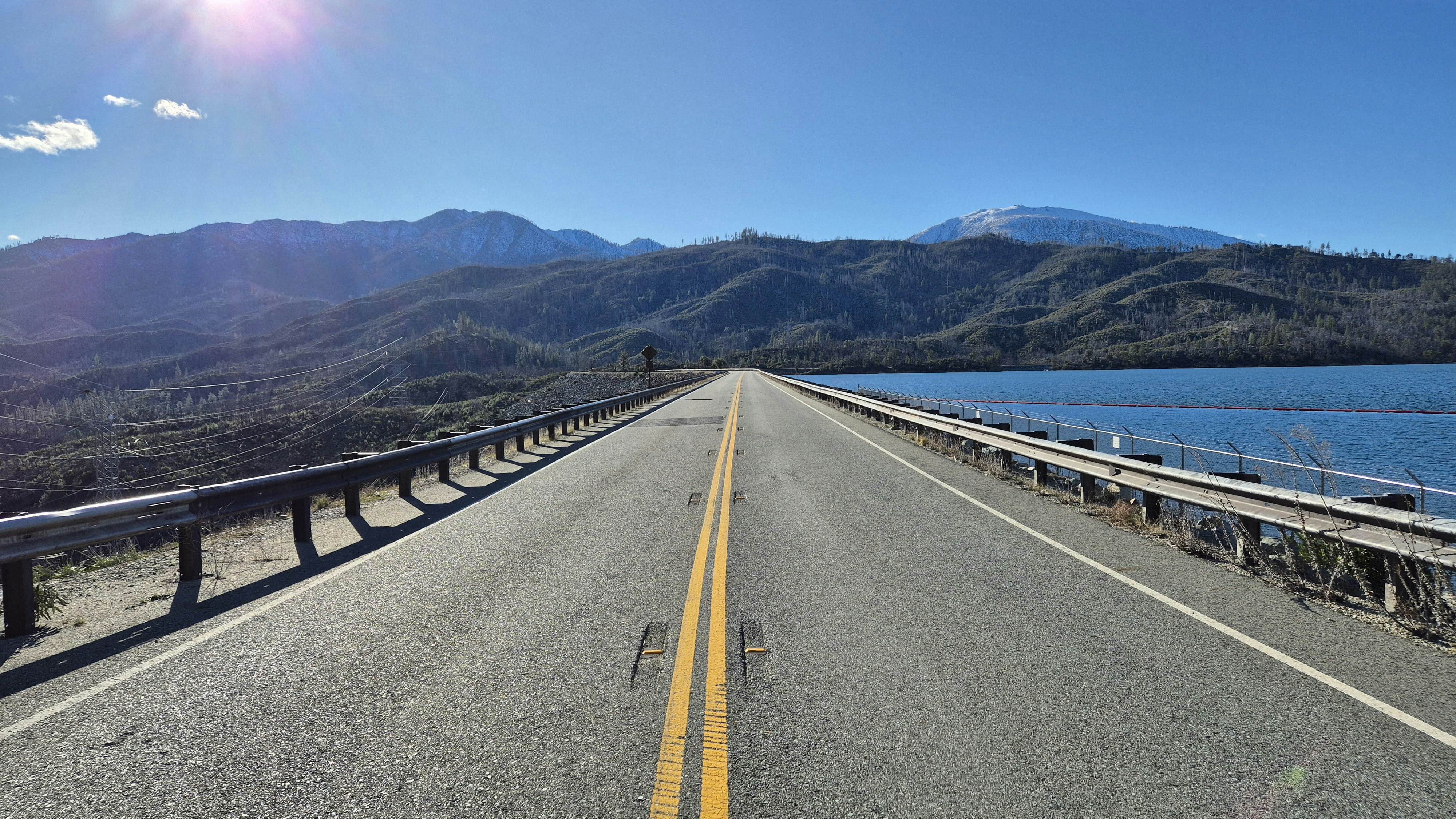 A view of a road with mountains in the background photo – Free Blue ...