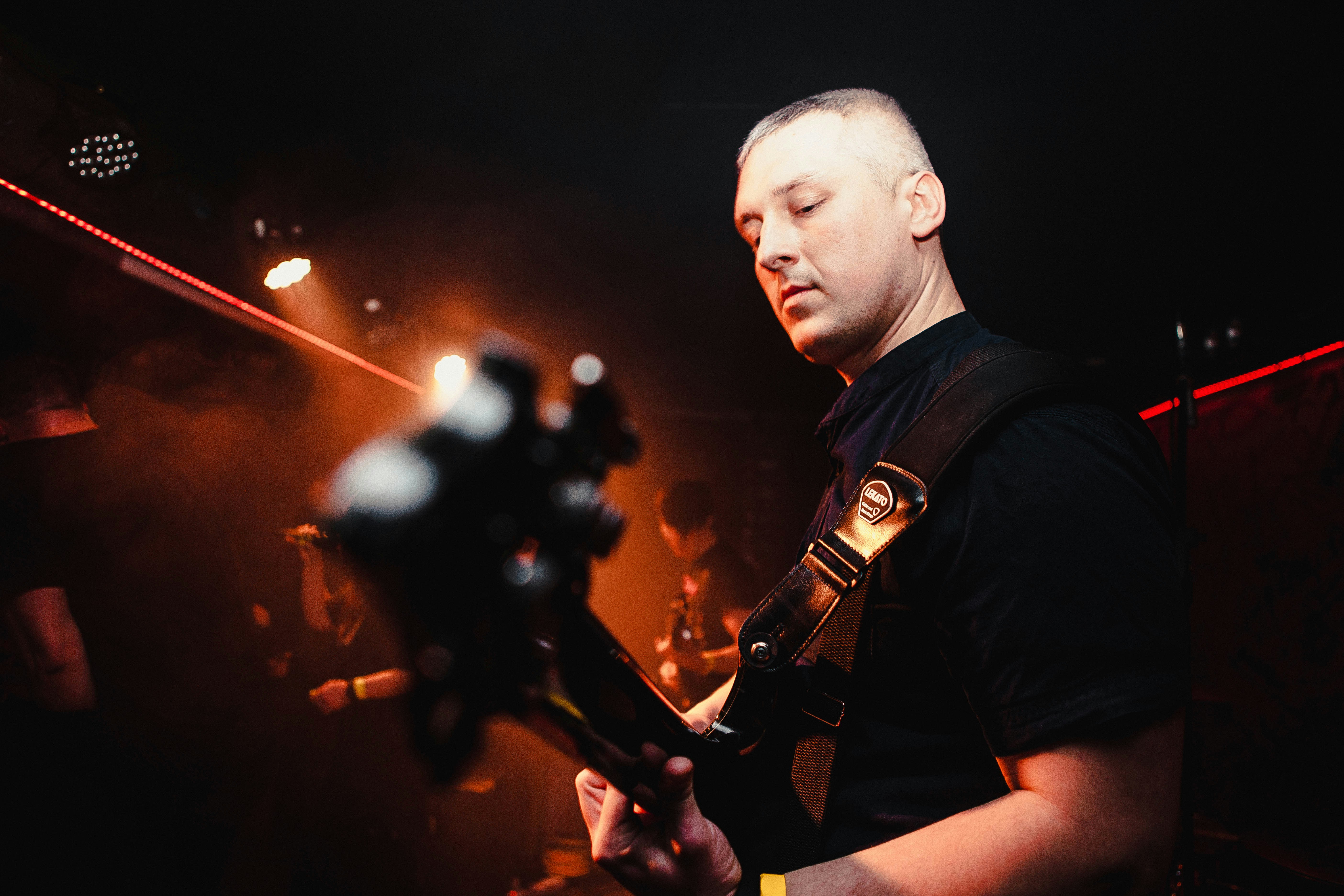 A man playing a guitar in a dark room
