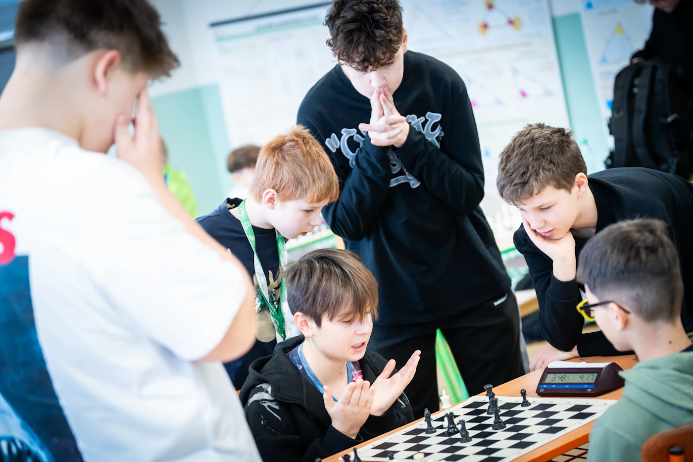 Students gathered around a chess board