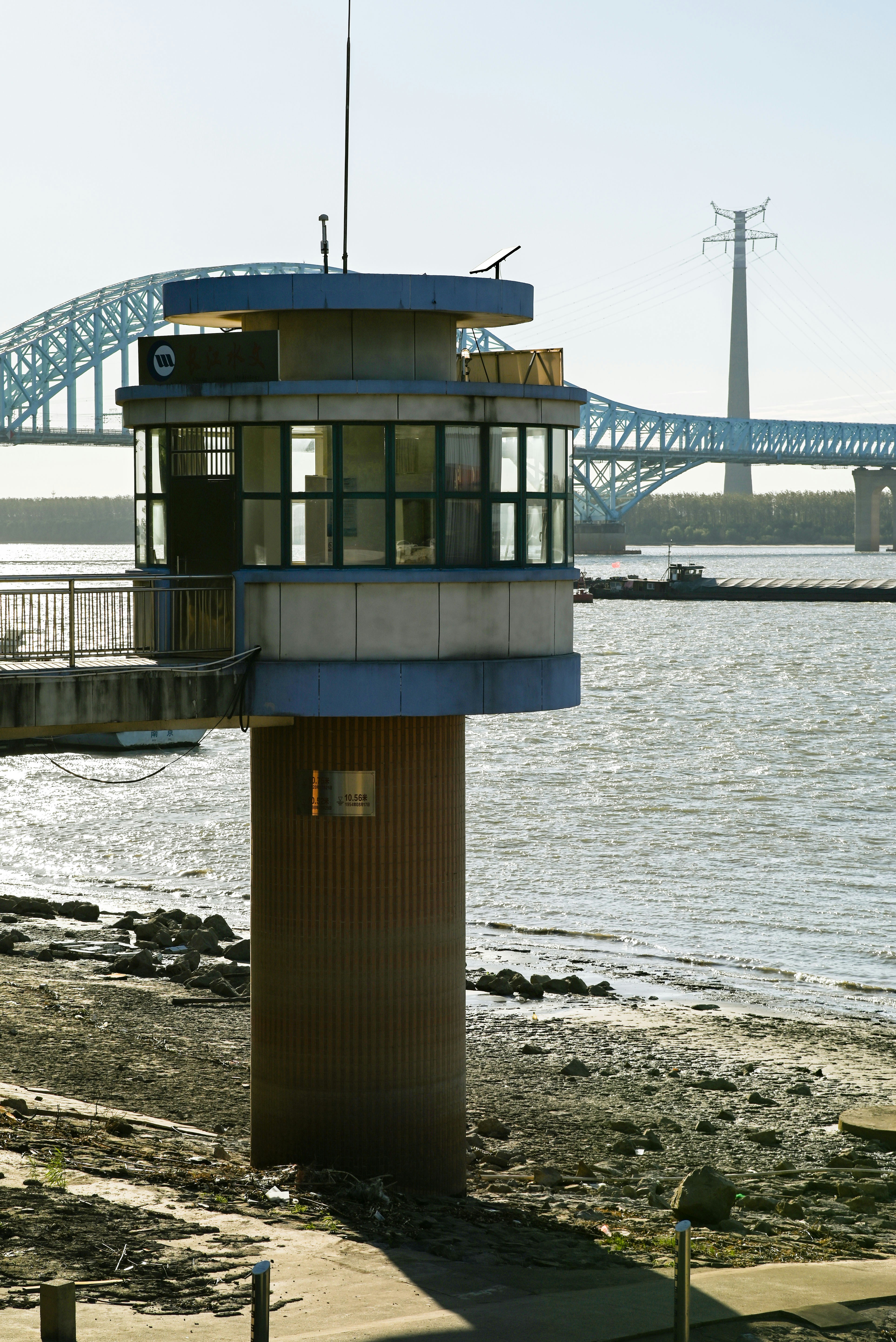 A tower on the shore with a bridge in the background