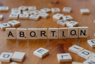 A wooden block spelling the word abortion on a table