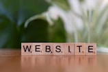 A wooden block spelling the word website on a table