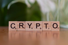 A wooden block spelling crypt on a table